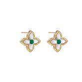 Gold quatrefoil stud earrings with white mother-of-pearl petals and emerald green gemstone center on beige background.