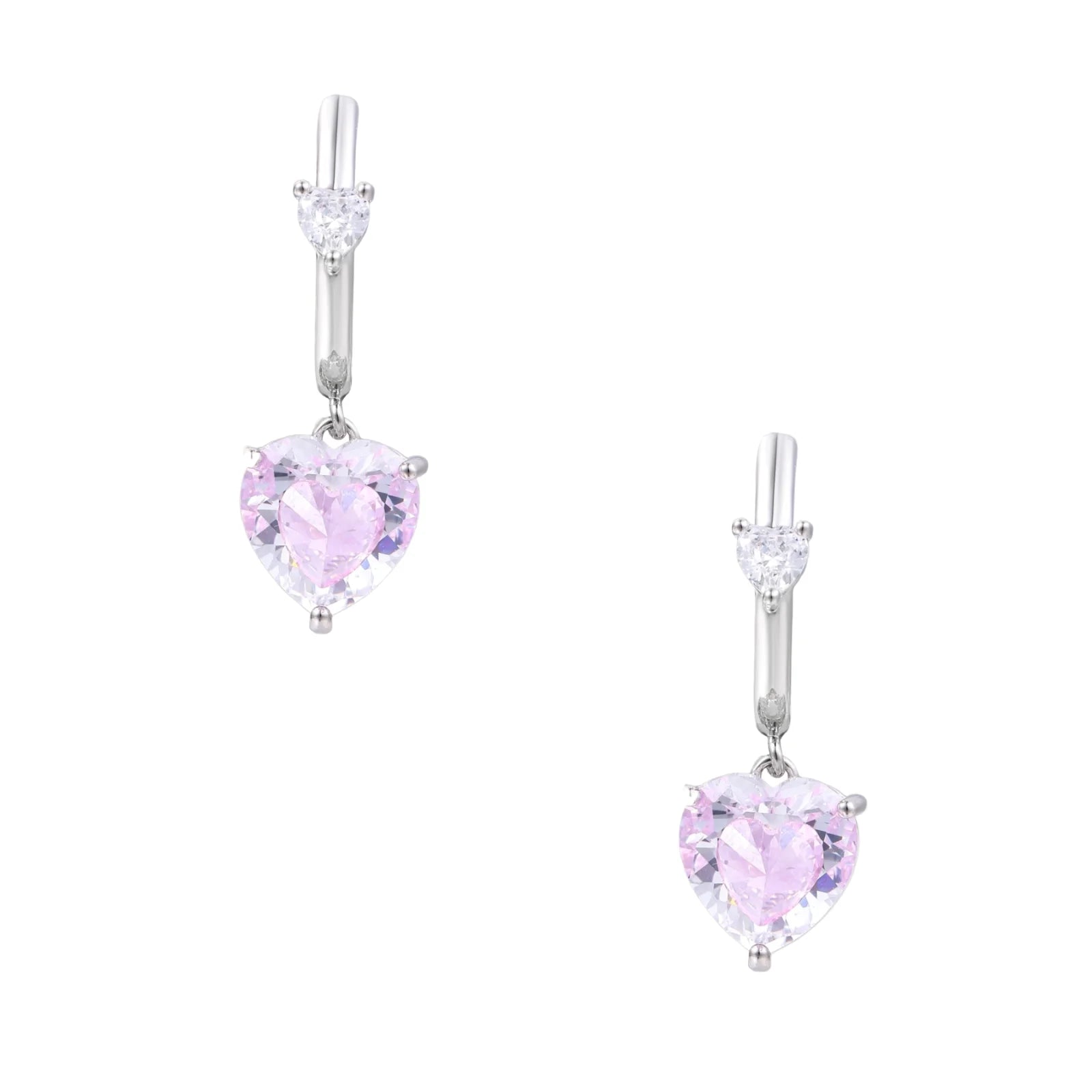 Silver huggie hoops with pink heart-cut zirconia pendants on white background, eco-friendly white gold plated brass