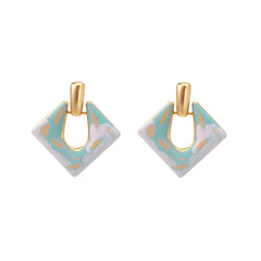 Geometric square enamel earrings with marbled turquoise and lavender pattern, gold U-shaped connector on cream background.