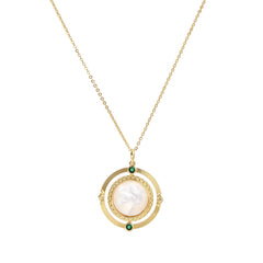 Gold pendant necklace with circular orbital design, iridescent mother-of-pearl center, and green zirconia accents