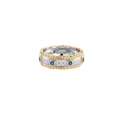Two-tone ring with brushed silver center, gold beaded edges, and blue zirconia stones on white background.